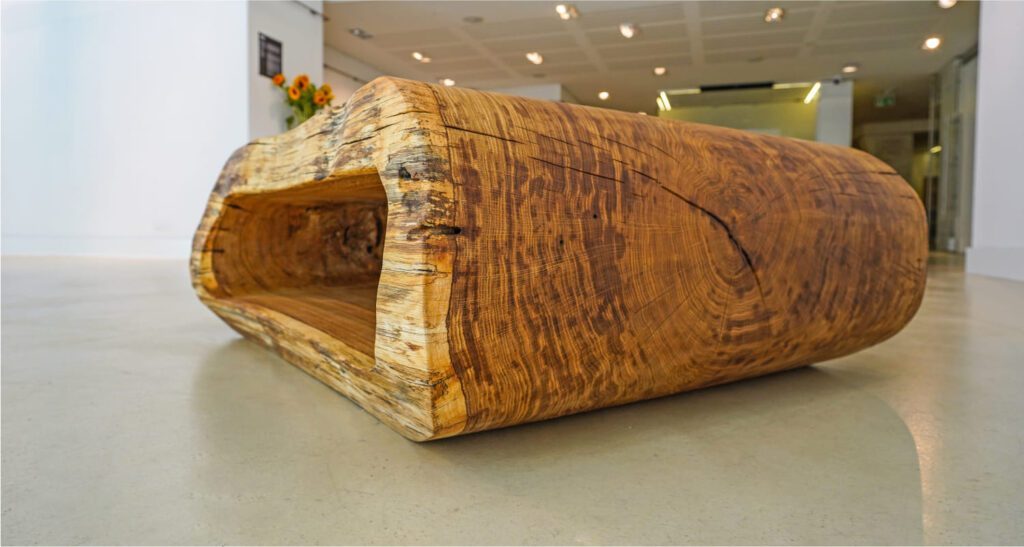 Close-up of OZE solid wood coffee table showing detailed wood grain, cracks, and natural edge