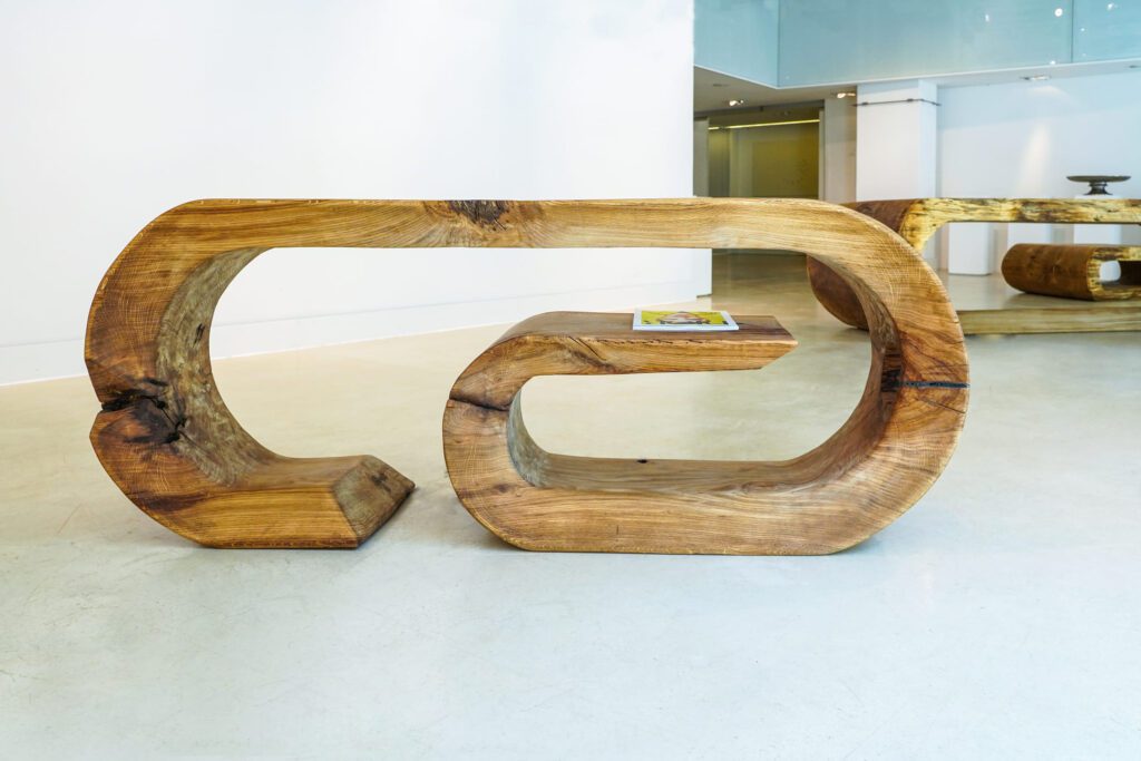 OZE sculptural wooden commode with integrated shelf displayed in a white gallery space